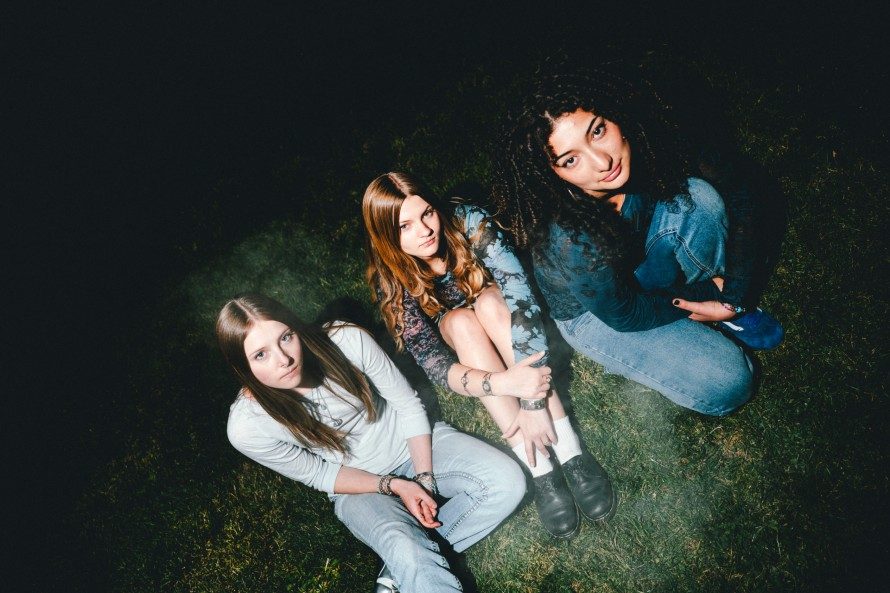 The band sitting on the grass at night